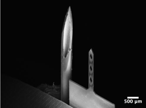 开孔钛基微针（200um宽，50um厚，1500um长）和26G皮下注射针（外径464um）对比的扫描电子显微镜照片